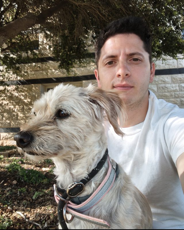 David Zeff outdoors with his dog, a scruffy cream-coloured terrier.